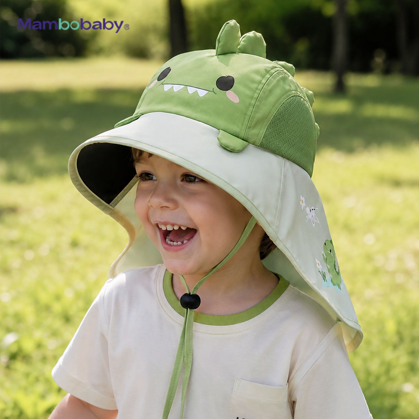 Child wearing the Mambobaby Dino sun hat outdoors in green