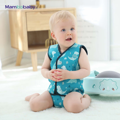 Baby sitting indoors wearing Mambobaby thermal wetsuit, Dino Blue, holding a ball